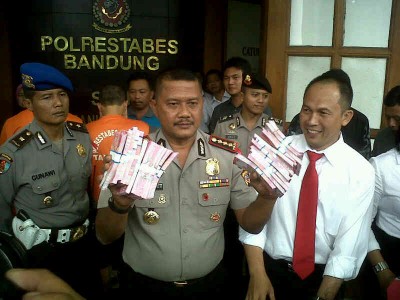 Kepala Polrestabes Bandung Komisaris Besar Mashudi memperlihatkan uang palsu pecahan Rp 100 ribu dalam ekspose di Mapolrestabes Bandung, Senin (24/2). Polisi telah mengamankan pembuat juga pemesan uang palsu tersebut. (JABARTODAY/AVILA DWIPUTRA)