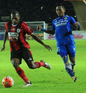 Bek sayap Persib, Tony Sucipto bekerja keras menghadang pergerakan Tinus Pae, dalam laga di Stadion Si Jalak Harupat, Sabtu (12/11). (net)