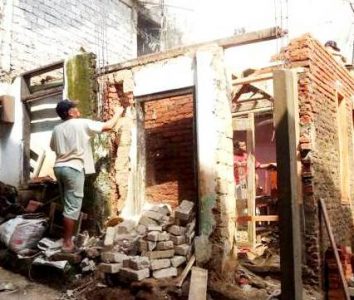 Pekerja sedang merenovasi rumah tidak layak huni. (net)
